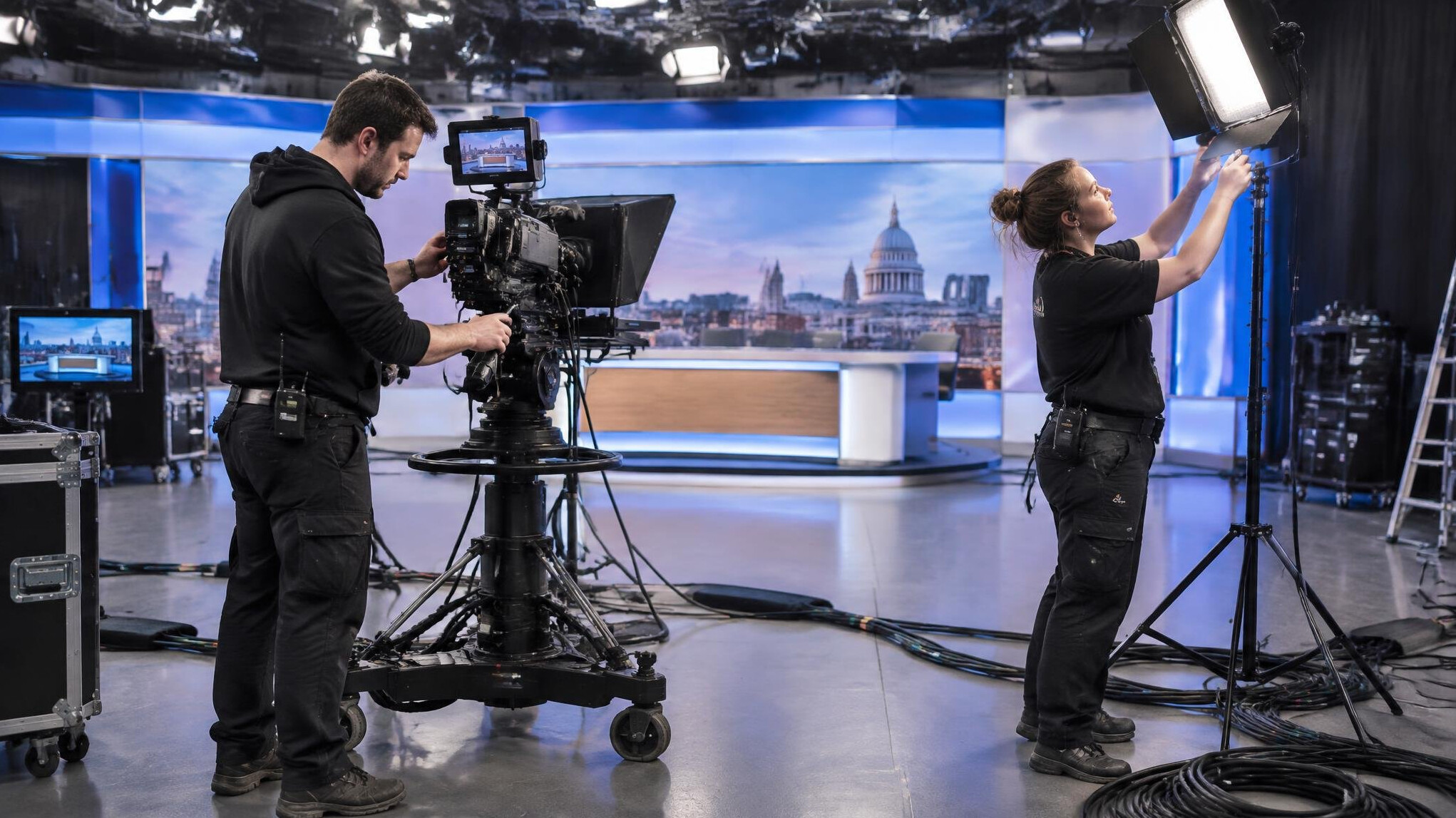 Technicians rigging camera and lighting equipment before a live broadcast